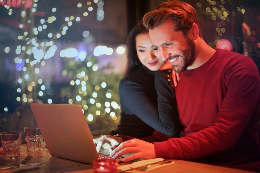 Man and woman in bar looking at laptop