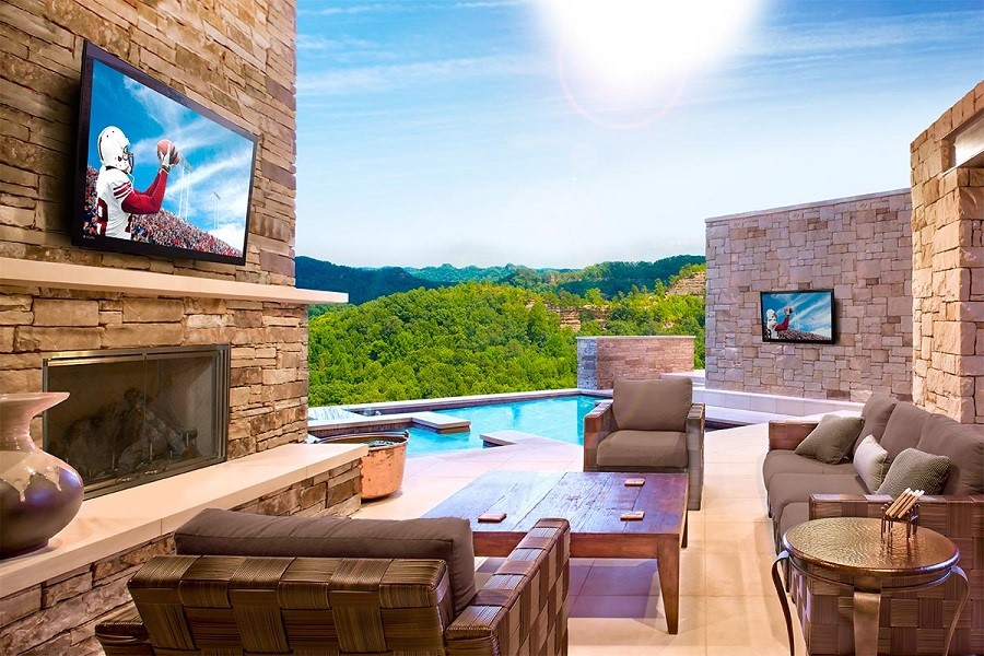 Outdoor pool and patio with TVs and fireplace