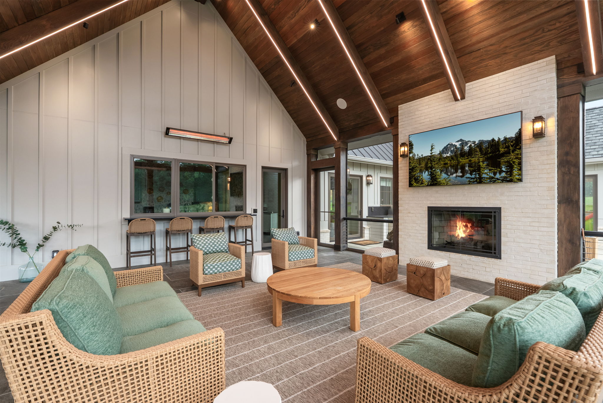 Outdoor seating area with a fireplace and television