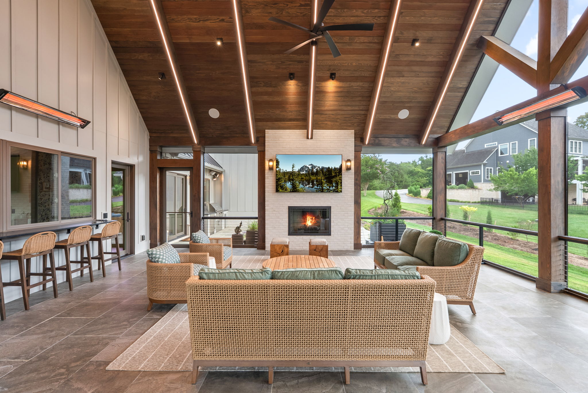 Covered outdoor living room with a fireplace and television