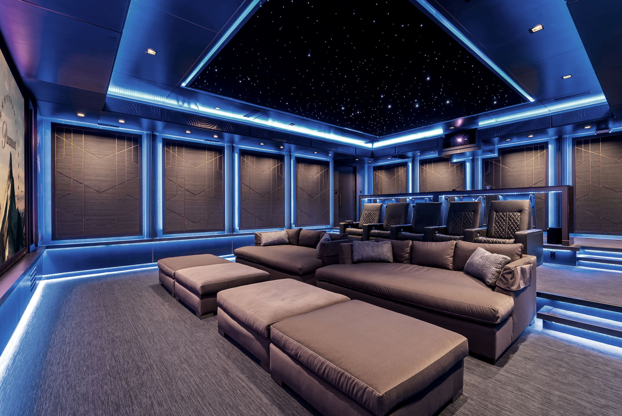 Cinema seating beneath a star ceiling and blue lighting