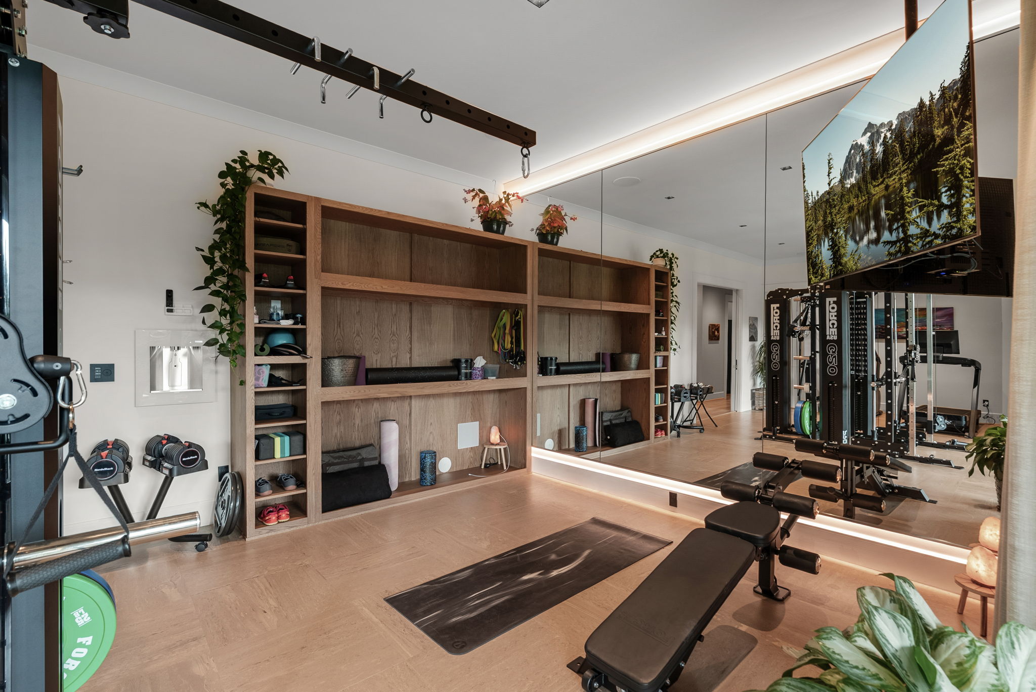 Fitness room with exercise equipment and a wall-mounted television